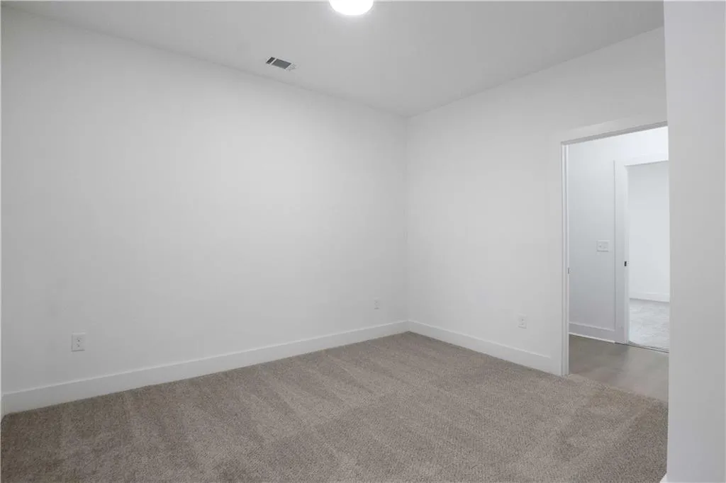 Spare room featuring carpet and baseboards