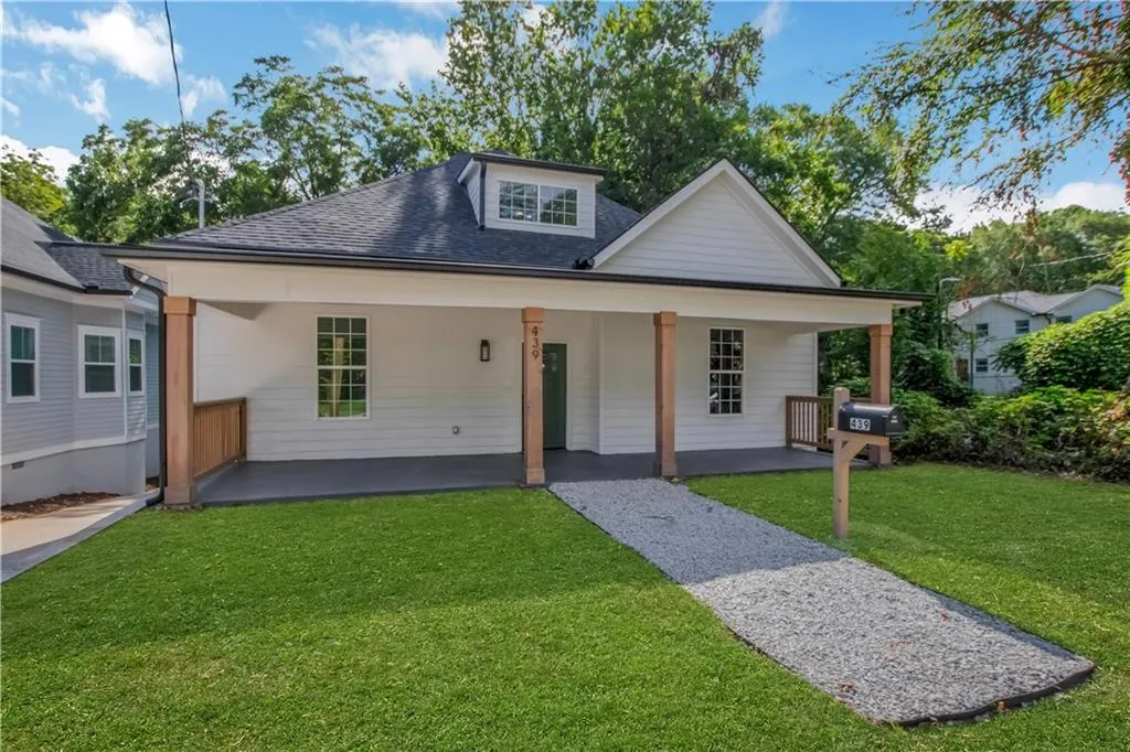 Bungalow with a front yard and roof with shingles