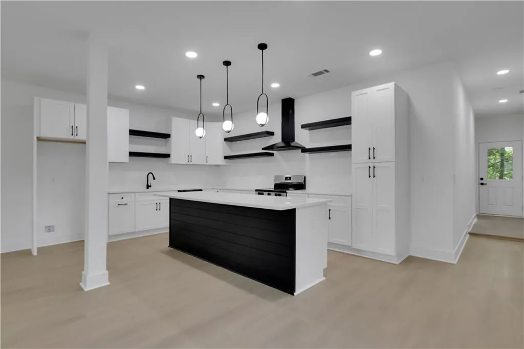 Kitchen with open shelves, white cabinetry, recessed lighting, wall chimney exhaust hood, and light wood-style flooring