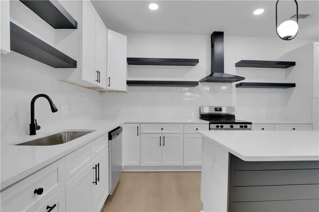 Kitchen with open shelves, white cabinetry, wall chimney exhaust hood, stainless steel appliances, and light wood-style flooring