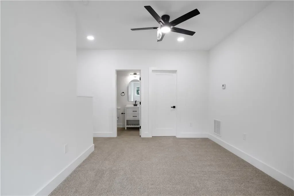 Unfurnished bedroom with light carpet, connected bathroom, recessed lighting, and ceiling fan