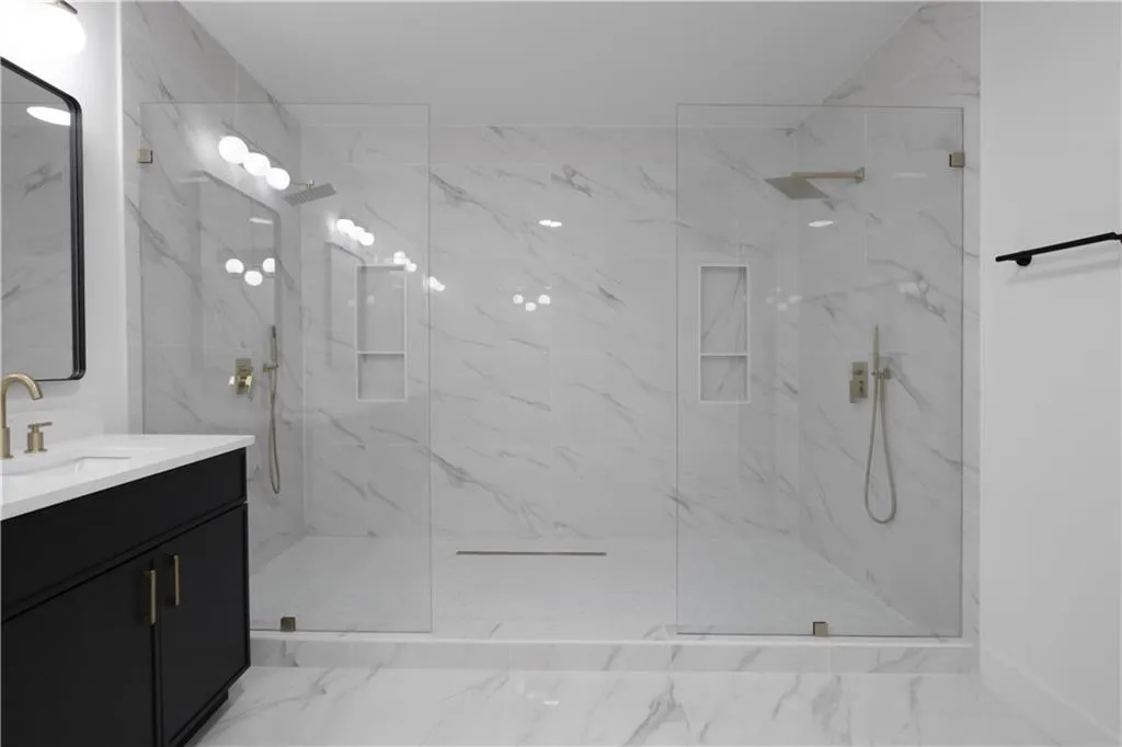 Bathroom with vanity and a marble finish shower