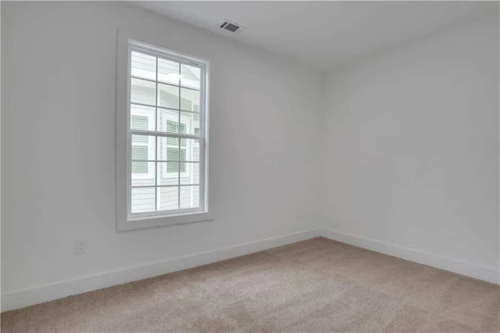 Unfurnished room with baseboards and light colored carpet