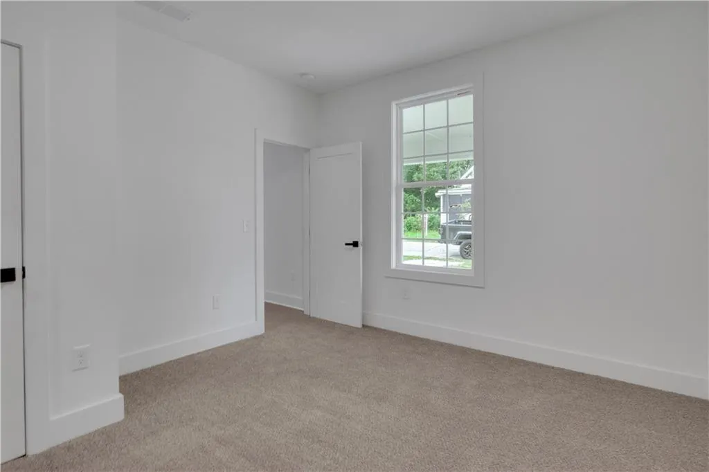 Spare room featuring baseboards and light colored carpet