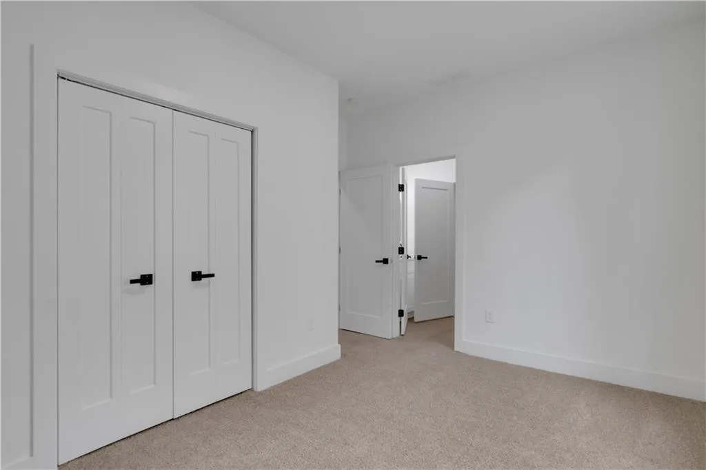 Unfurnished bedroom featuring light carpet and a closet
