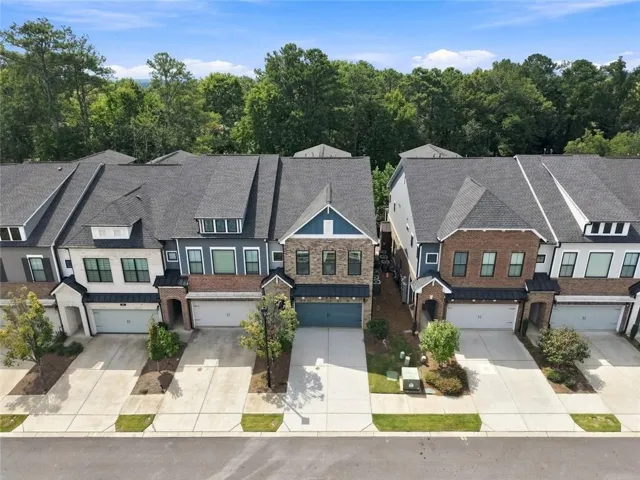 Contemporary townhome architecture featuring brick and siding accents, prominent gables, and attached garages