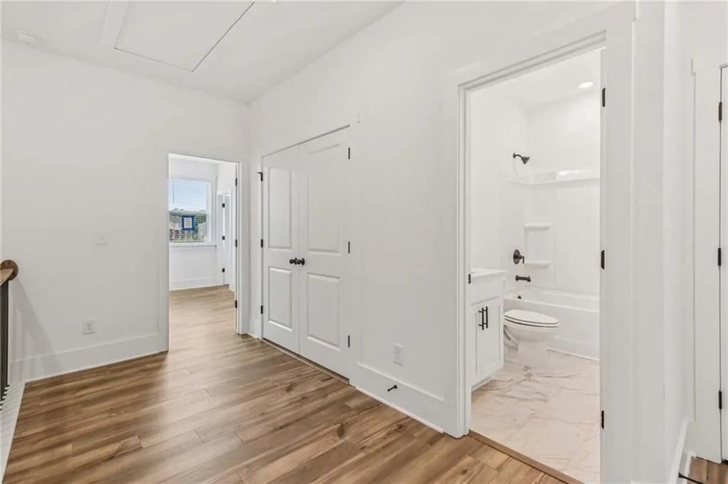 Hallway with baseboards and wood finished floors