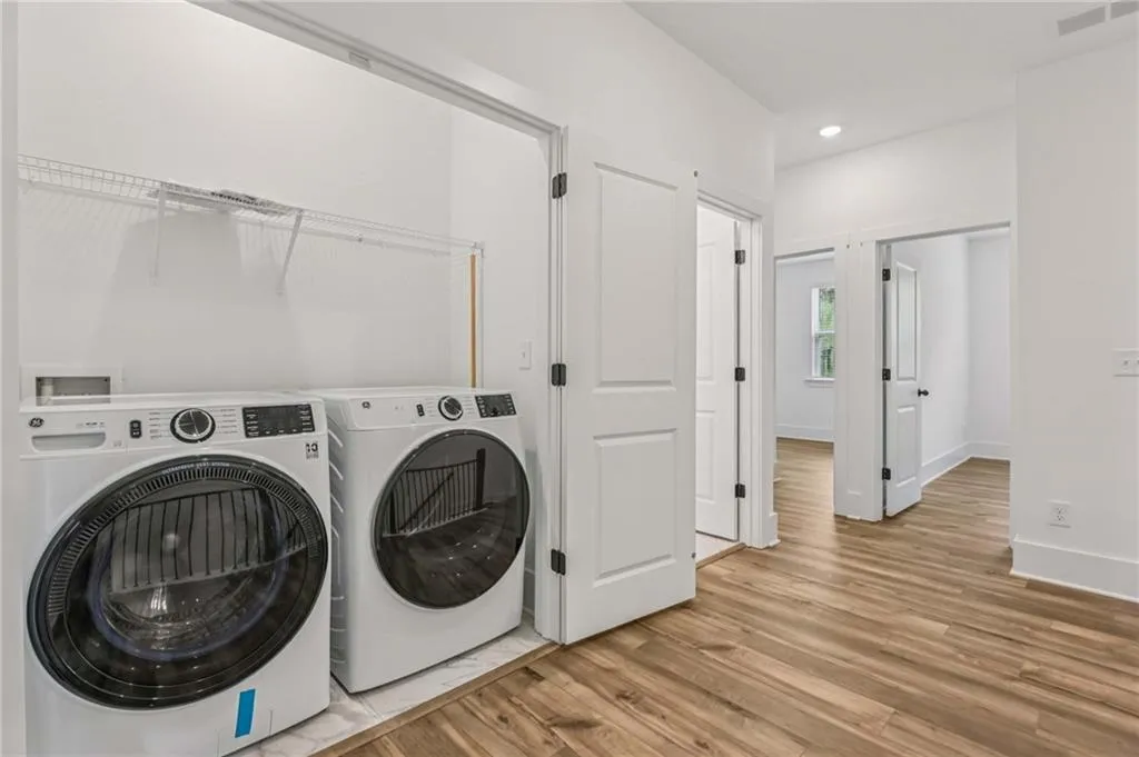 Laundry area featuring washing machine and clothes dryer, light wood-style floors, and recessed lighting