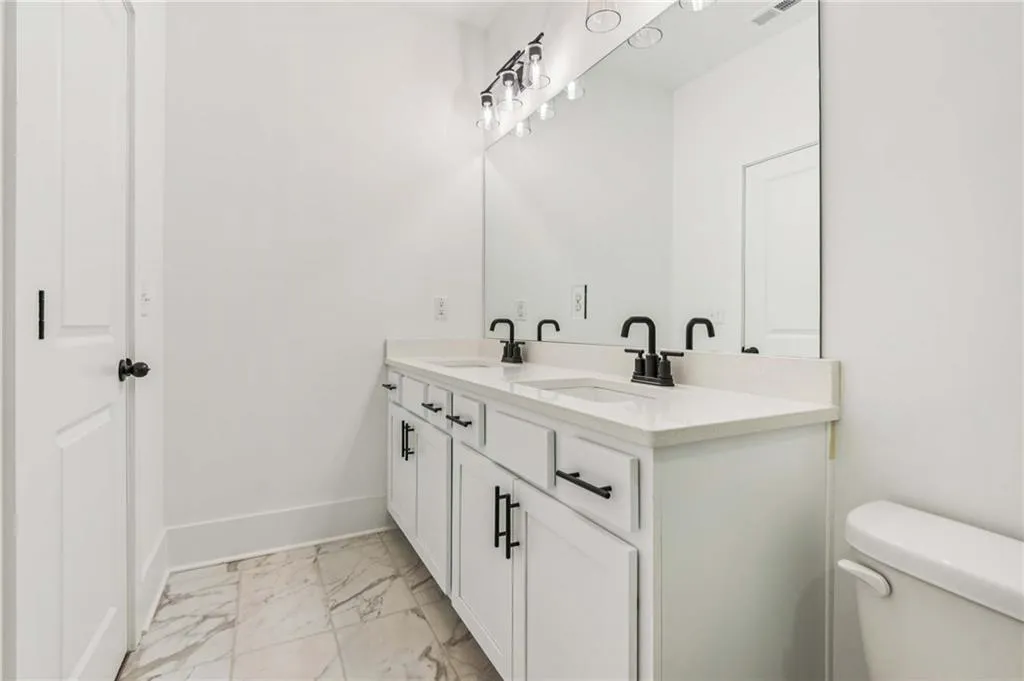 Bathroom with marble finish flooring and double vanity
