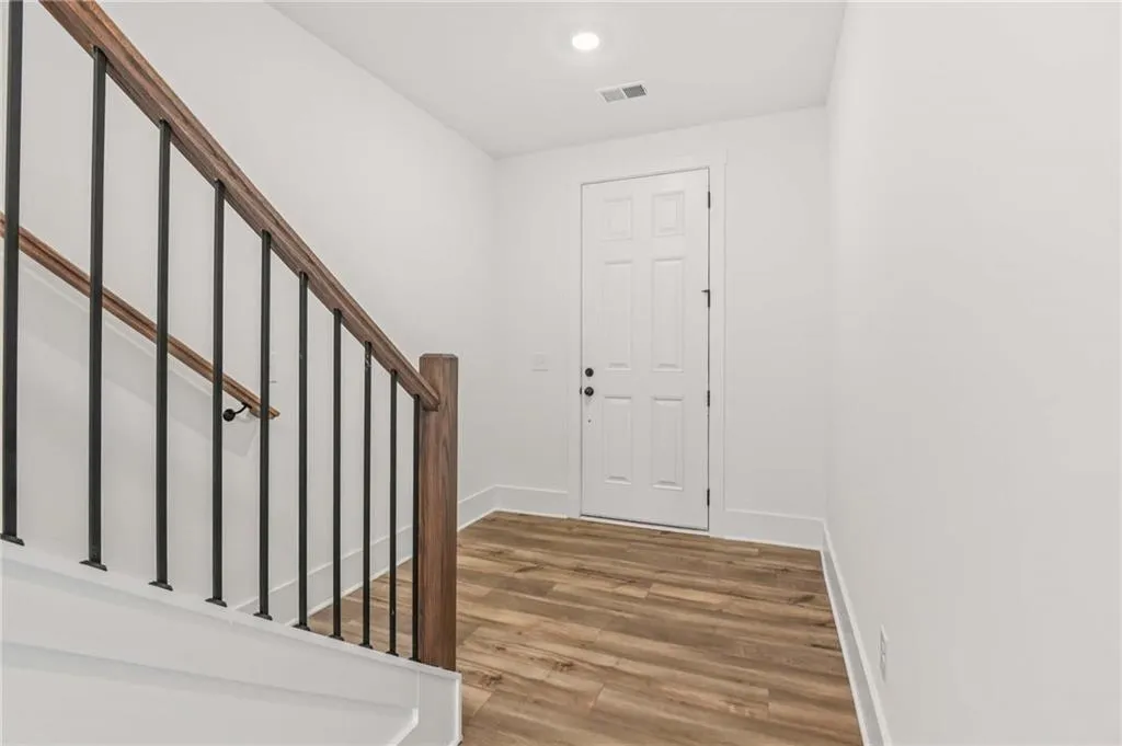 Entryway with wood finished floors, recessed lighting, and stairway