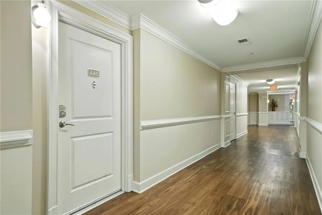 Corridor featuring ornamental molding and dark wood finished floors