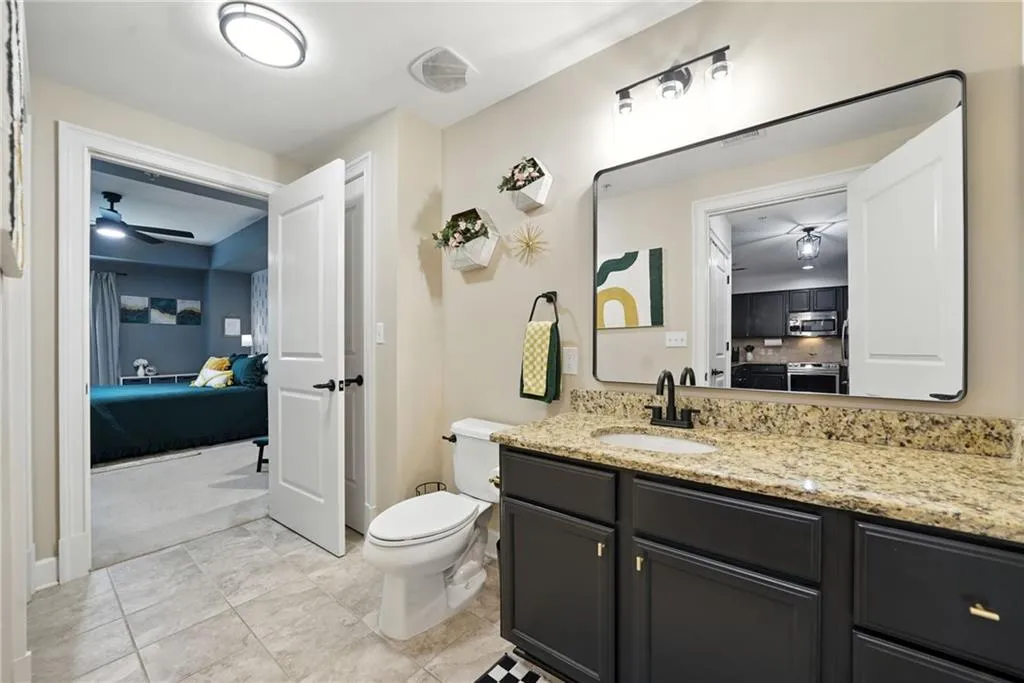 Full bathroom featuring ensuite bath, vanity, a ceiling fan, and tile patterned flooring