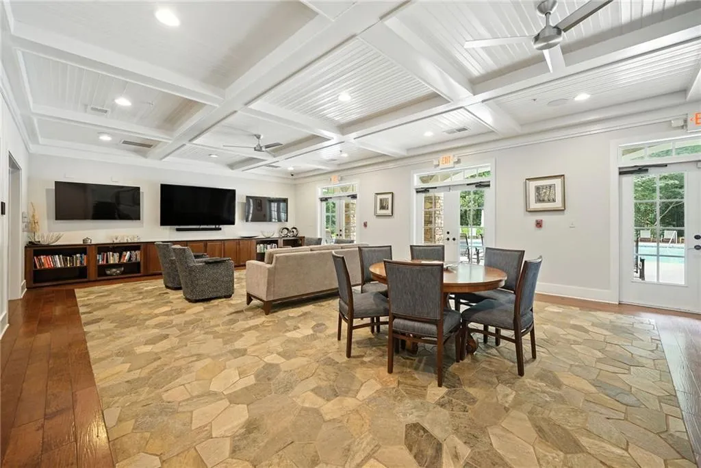 Dining space featuring beam ceiling, french doors, light wood finished floors, coffered ceiling, and a ceiling fan