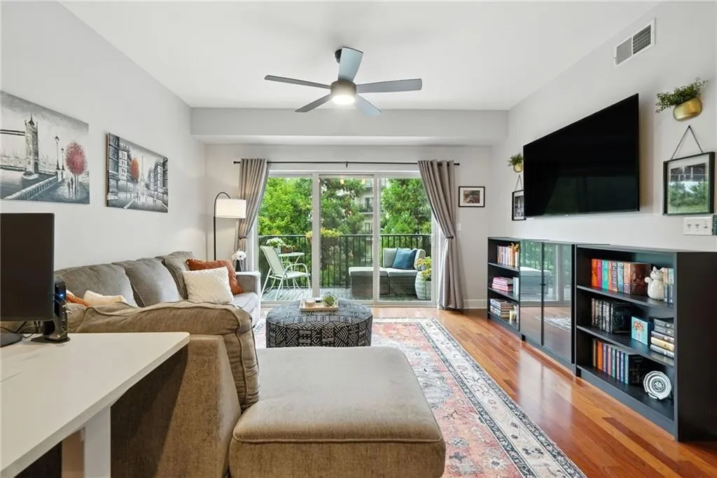 Living area with wood finished floors and a ceiling fan