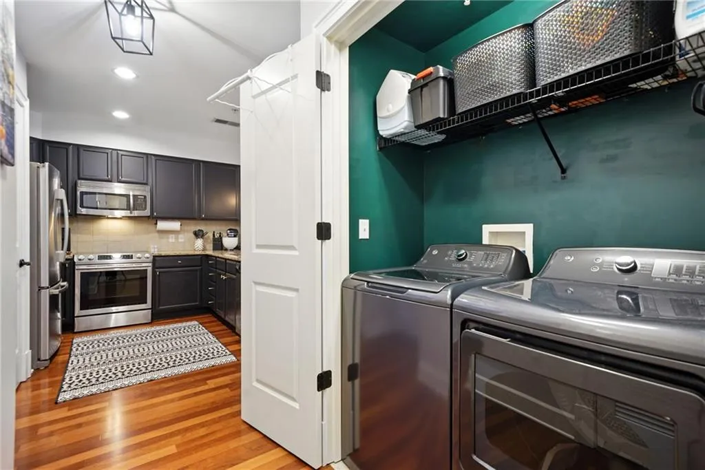 Laundry area with washer and clothes dryer, light wood-style flooring, and recessed lighting