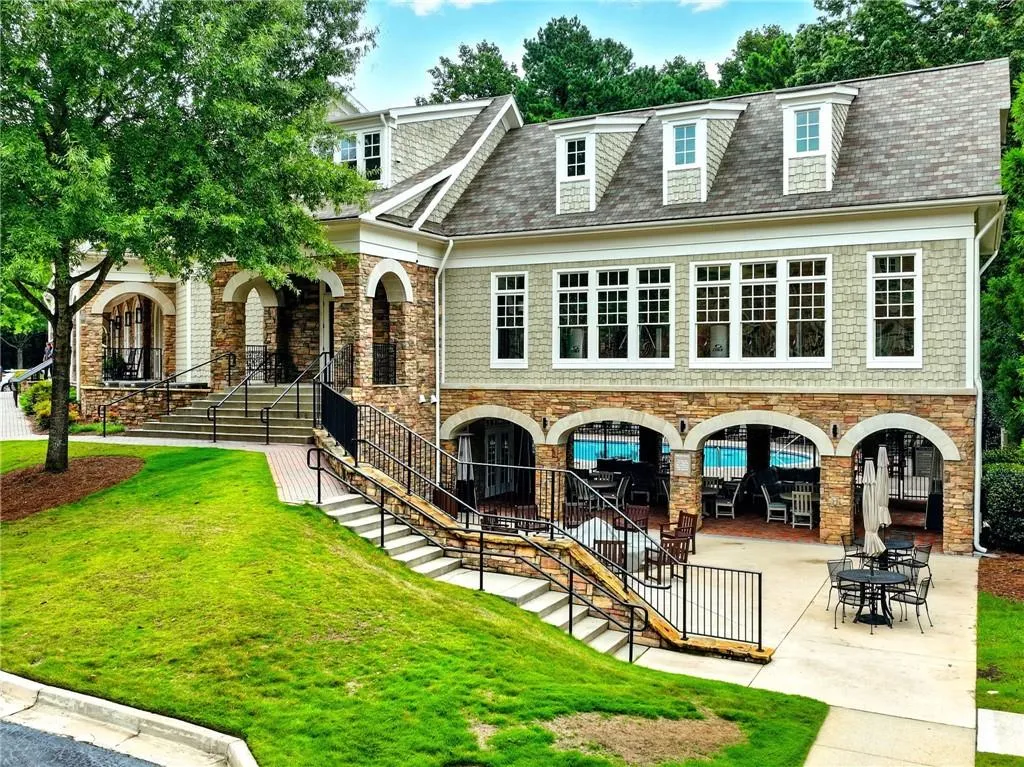 Back of house with a yard, stairway, stone siding, and a patio area