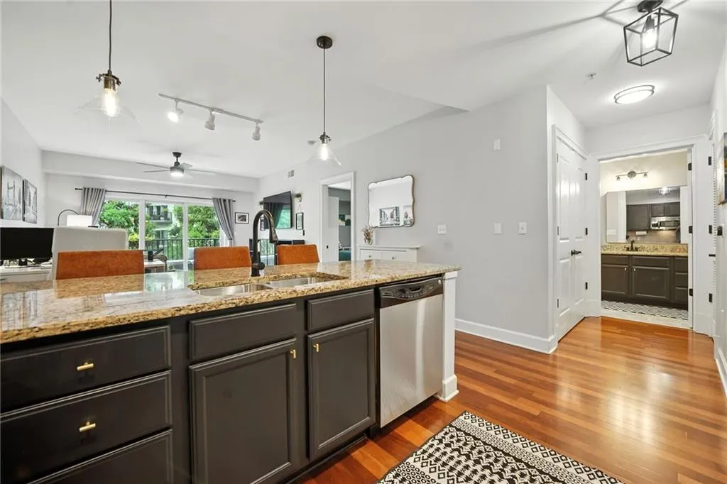 Kitchen with wood finished floors, dishwasher, pendant lighting, and track lighting