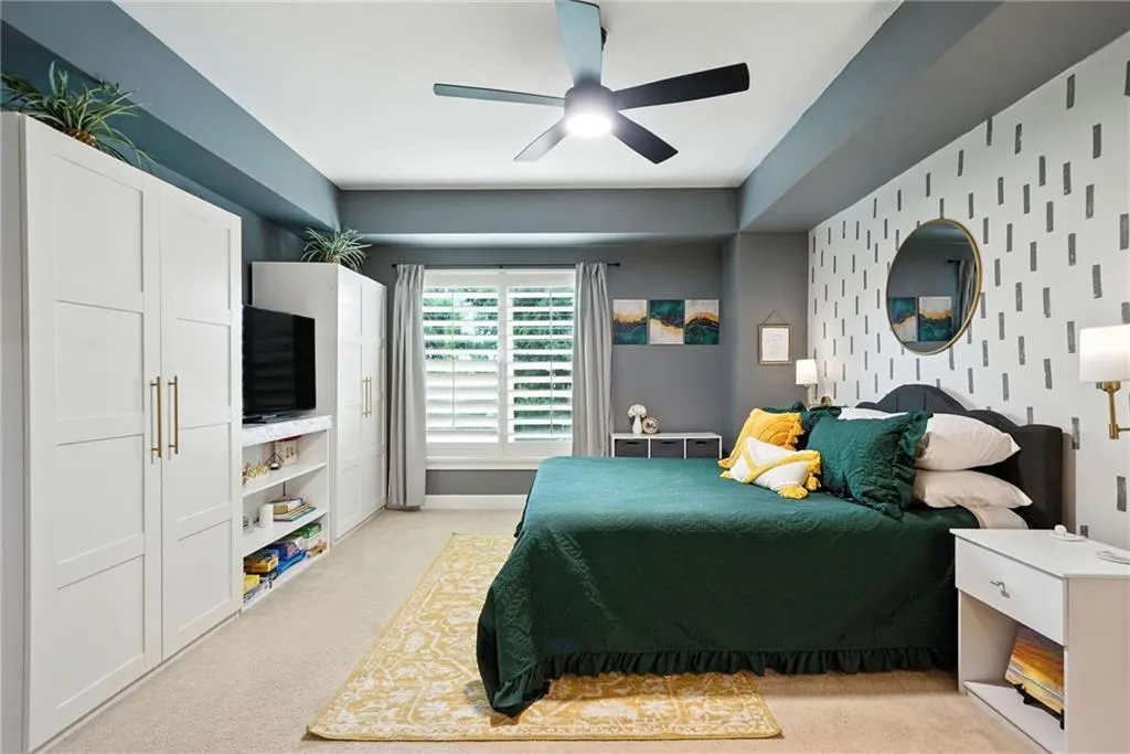 Bedroom featuring light carpet and a ceiling fan