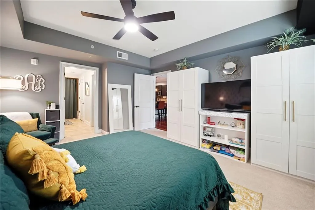 Bedroom with light carpet and a ceiling fan