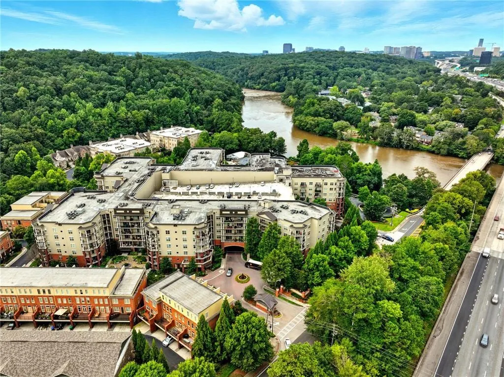 View of urban area featuring a heavily wooded area and a large body of water