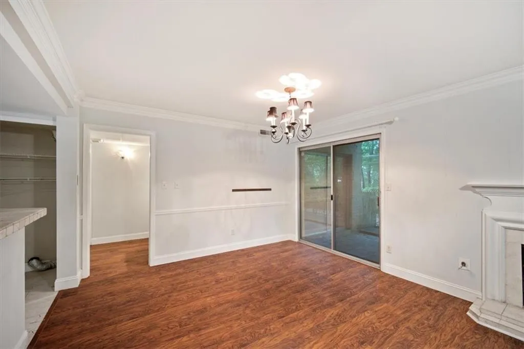 Unfurnished dining area featuring crown molding, a chandelier, and wood finished floors