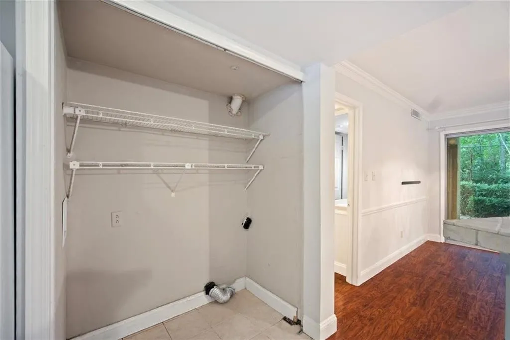 Laundry room with crown molding and baseboards