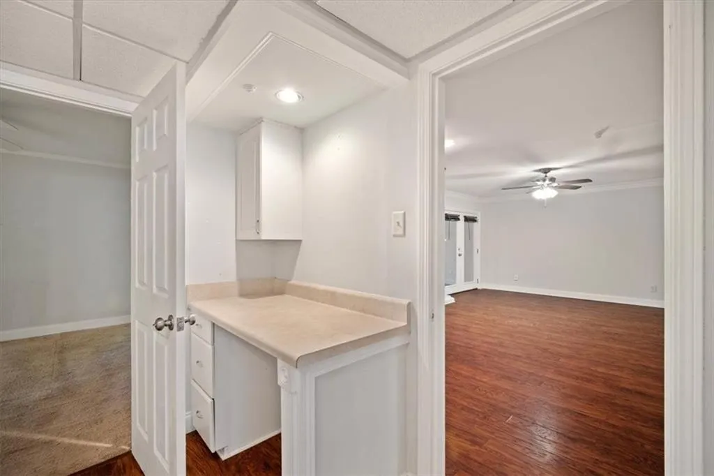 Hallway with dark wood finished floors and crown molding