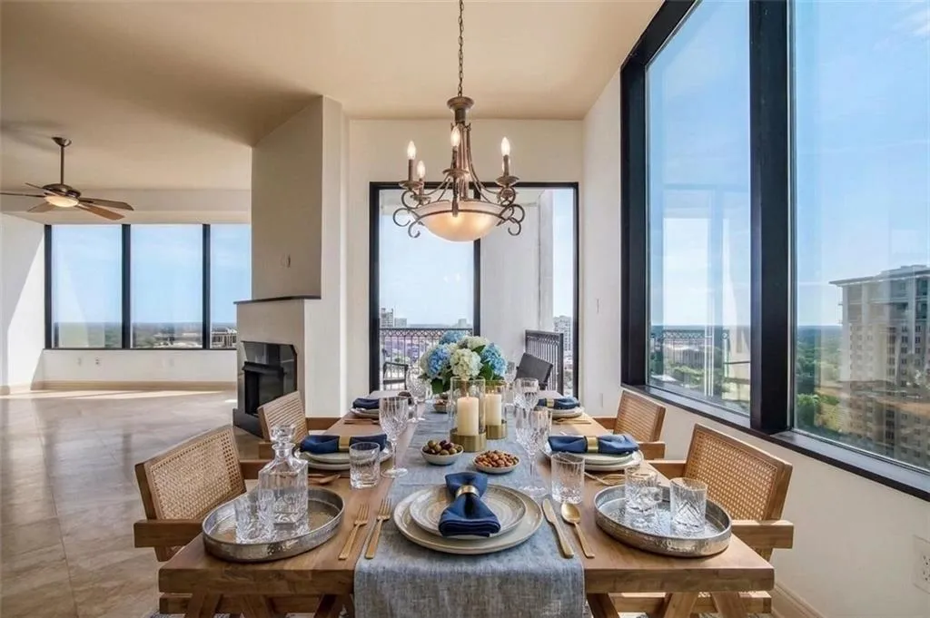 Dining area featuring floor-to-ceiling windows, a decorative chandelier, and light-toned flooring