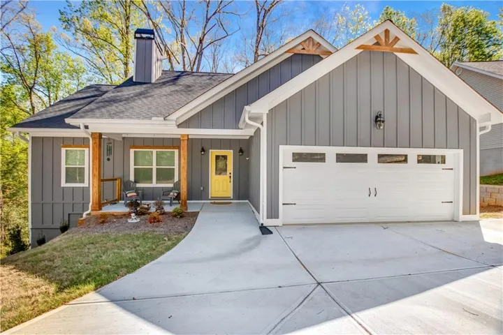 Contemporary exterior featuring board and batten siding, an attached garage with window inserts, and a concrete driveway