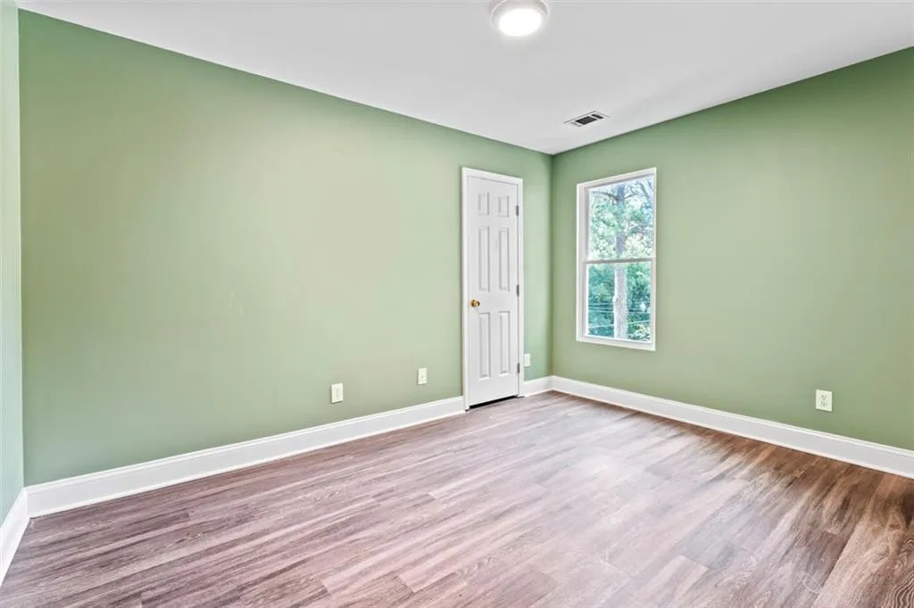 Spare room featuring wood finished floors and baseboards