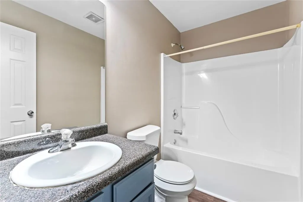 Full bath featuring vanity and washtub / shower combination
