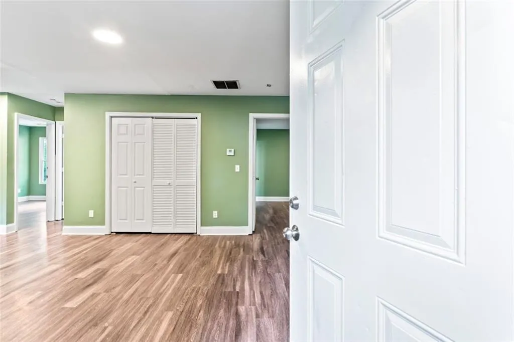 Unfurnished bedroom with wood finished floors and a closet