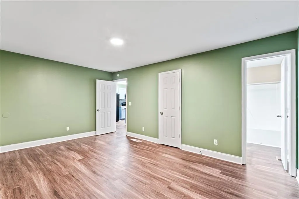 Unfurnished bedroom with light wood-type flooring and a walk in closet