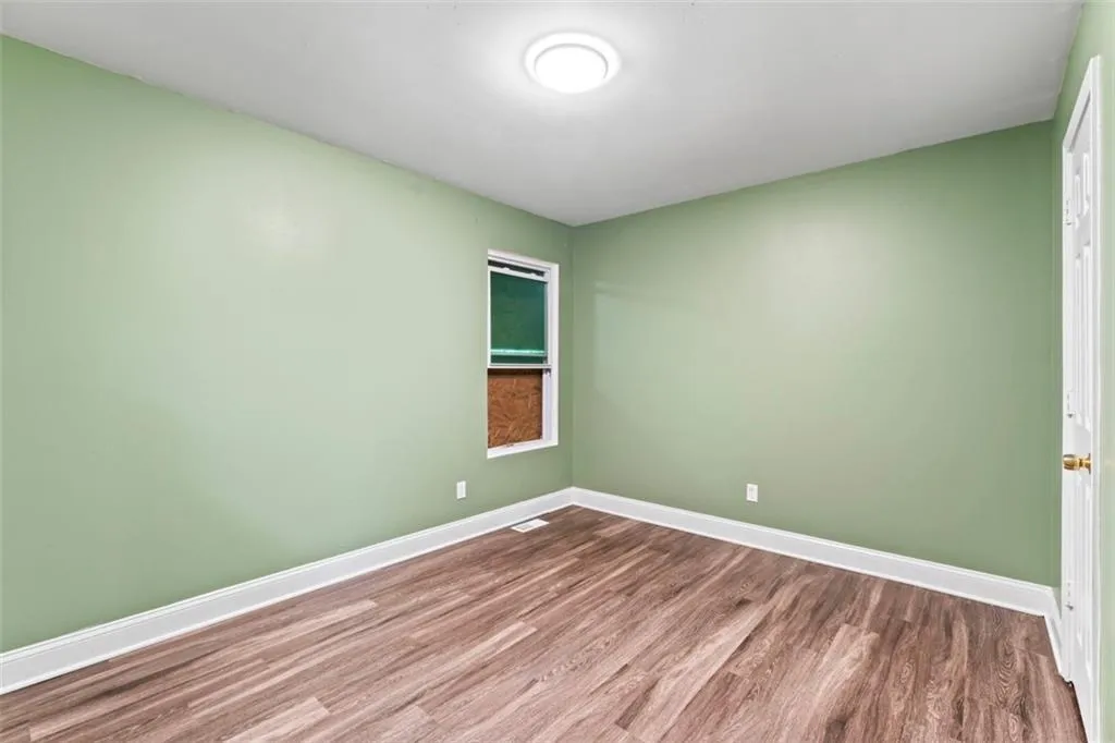 Empty room featuring wood finished floors and baseboards
