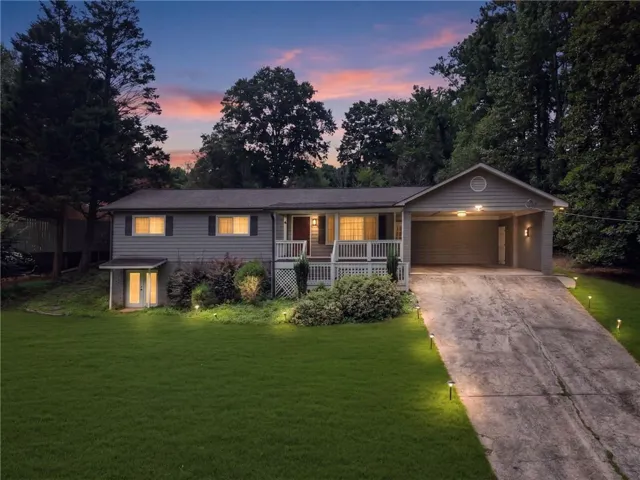 Single-story home featuring a covered carport, front porch with white railing, and a lower-level entrance