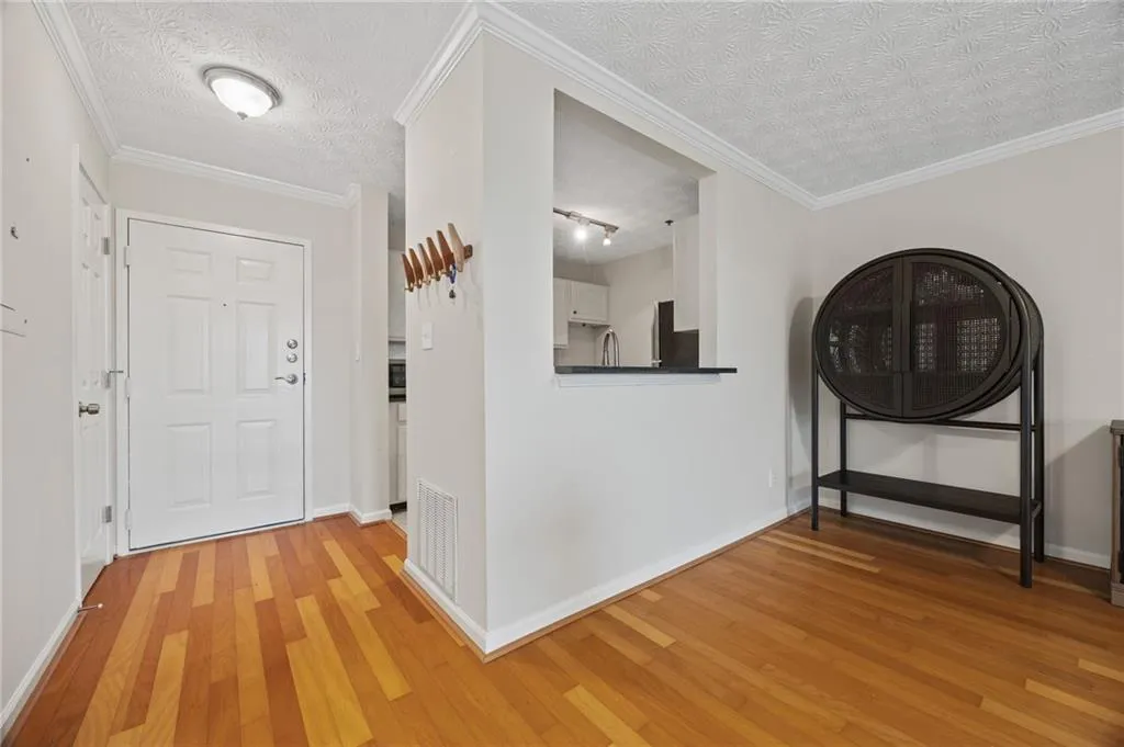 Hallway with visible vents, light wood-style flooring, and baseboards