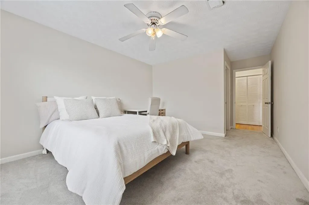 Bedroom featuring visible vents, light carpet, and baseboards