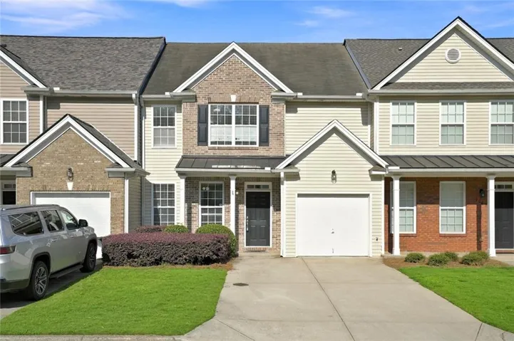 Exterior featuring brick and siding facade, covered entry, attached garage, and a concrete driveway
