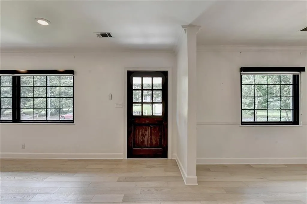 Foyer entrance featuring healthy amount of natural light, ornamental molding, light wood-style flooring, and recessed lighting