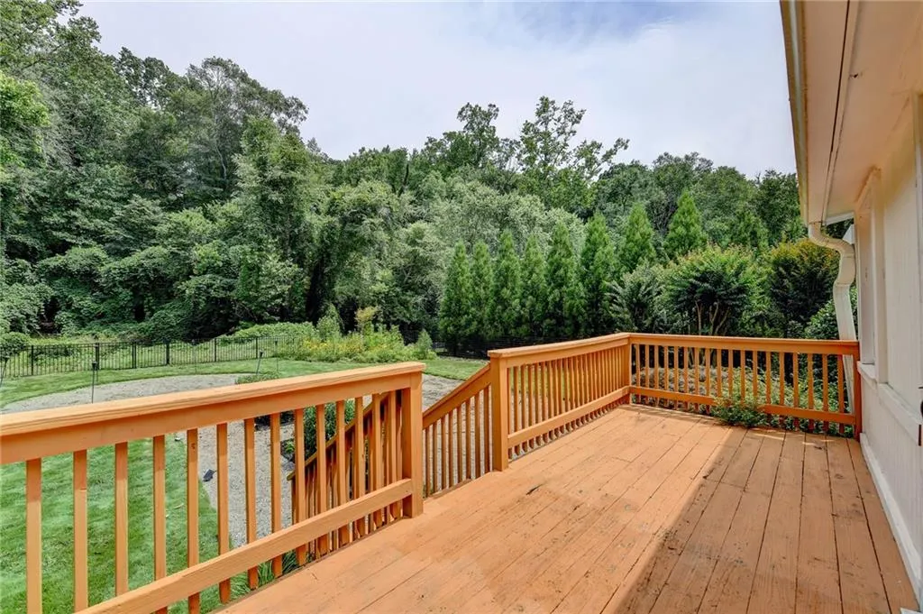 Deck with a fenced backyard and a forest view