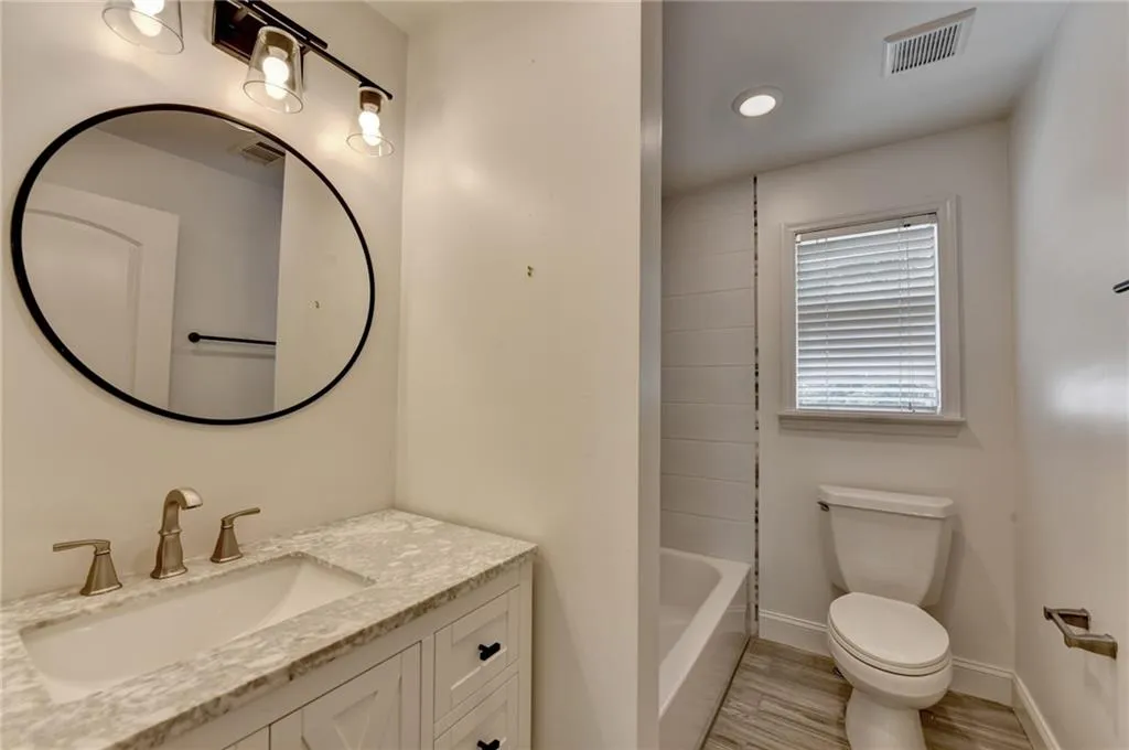 Full bathroom featuring vanity, wood finished floors, and bathtub / shower combination