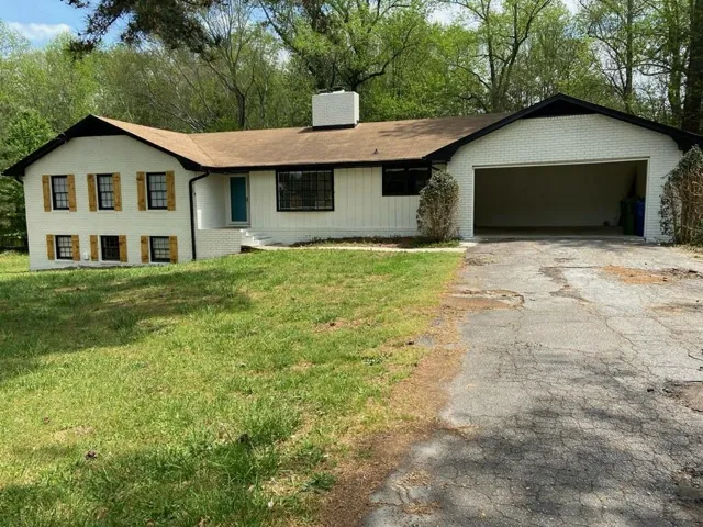 White brick exterior with a prominent two-car garage