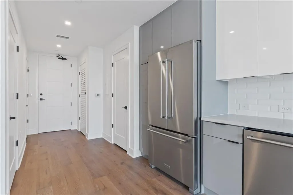 Kitchen featuring modern cabinets, stainless steel appliances, gray cabinets, light wood-type flooring, and light countertops