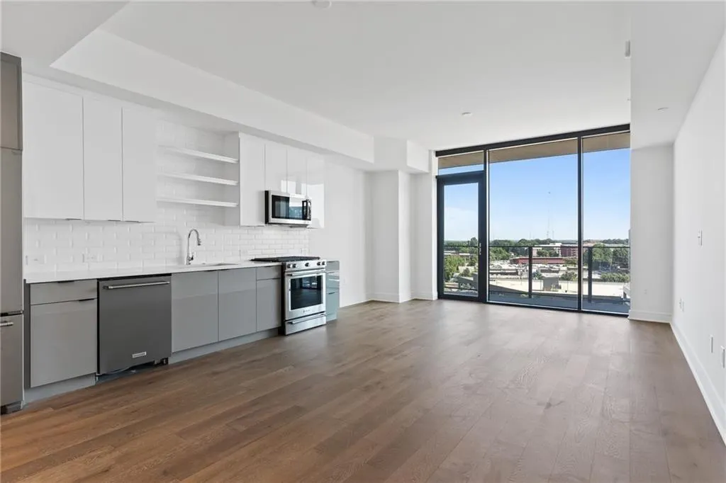 Kitchen with open shelves, decorative backsplash, expansive windows, appliances with stainless steel finishes, and dark wood-style flooring