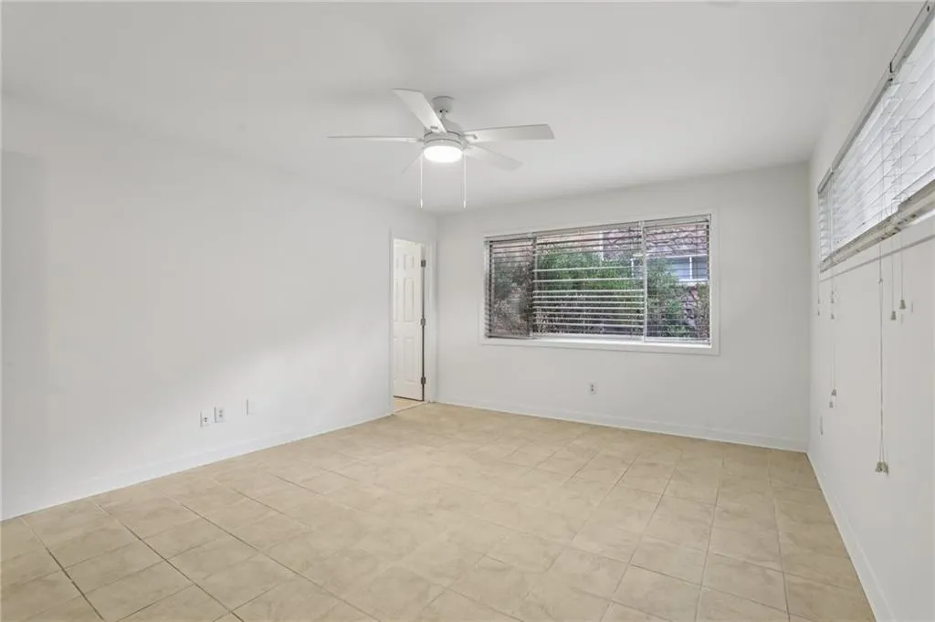 Unfurnished bedroom featuring light tile patterned floors, a ceiling fan, and a closet