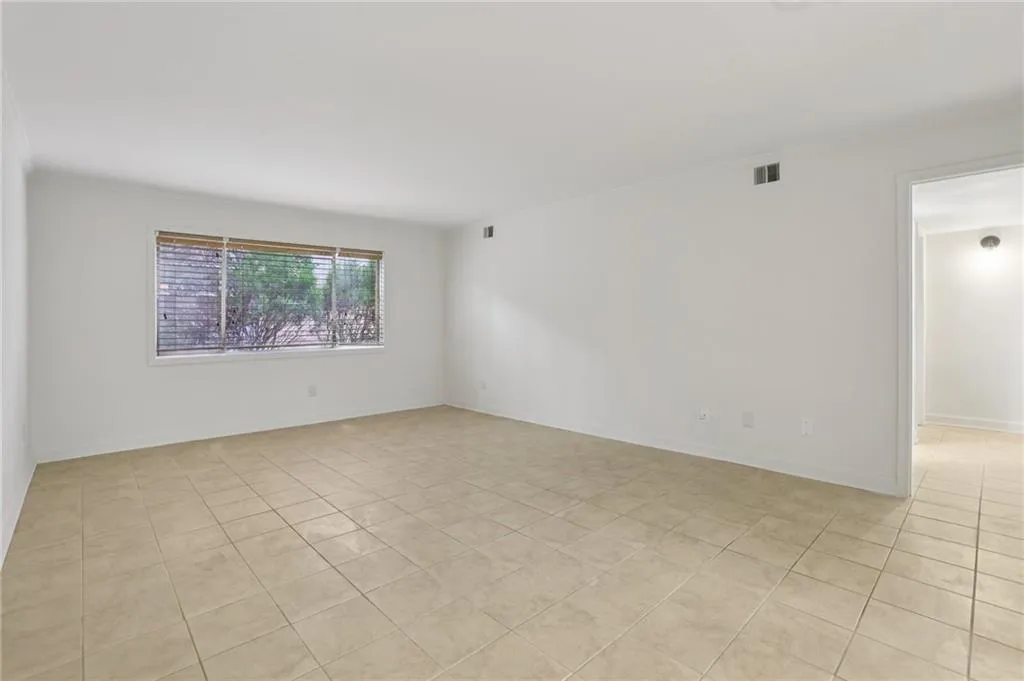 Empty room with ornamental molding and light tile patterned floors