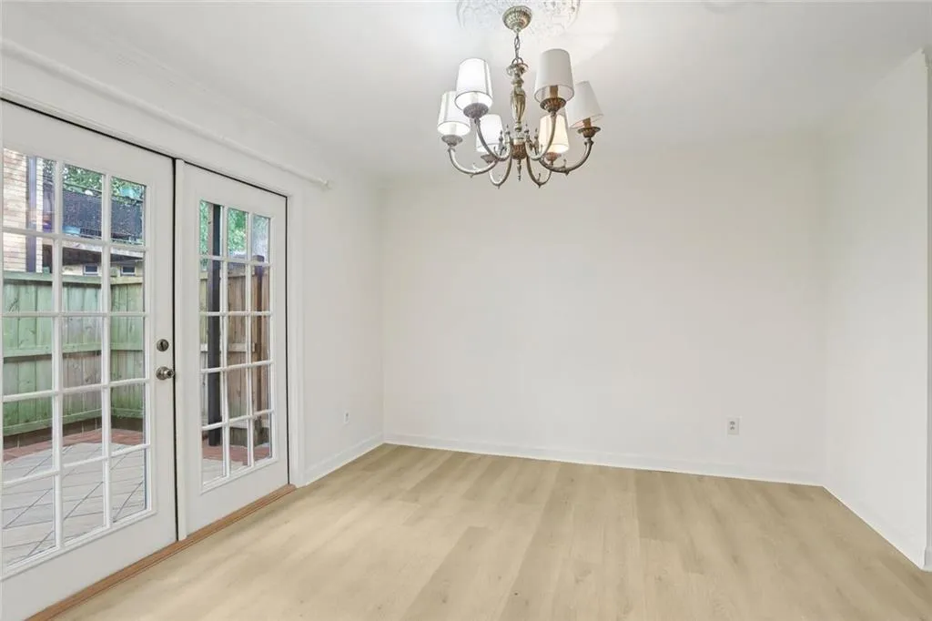 Unfurnished dining area featuring light wood-type flooring and a chandelier