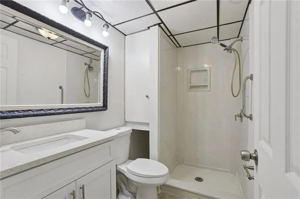 Full bathroom with vanity, a shower stall, and a paneled ceiling