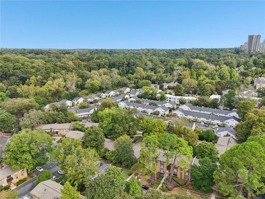 Aerial view of property and surrounding area with a forest
