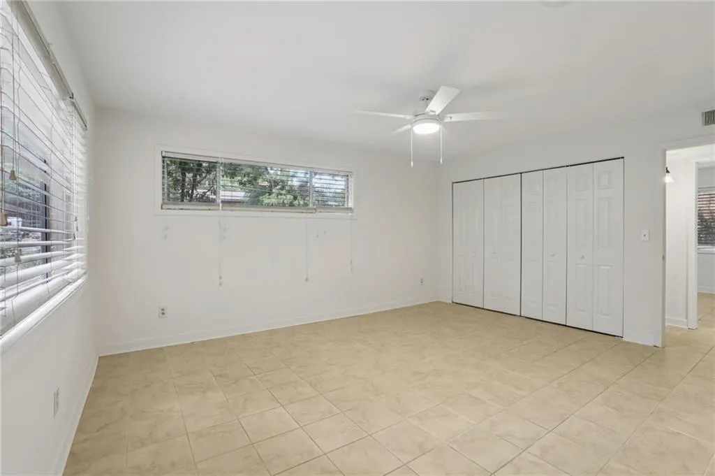 Unfurnished bedroom featuring a closet, ceiling fan, and light tile patterned floors